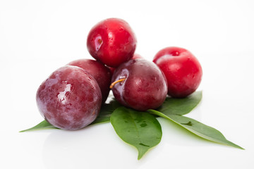 plums with plum leaves isolated on a white background