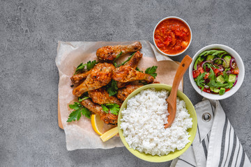 Baked chicken legs with rice and salad.