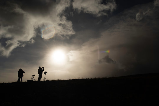 Silhouet of a photographer taking pictures of the Cotopaxi volcano during sunrise