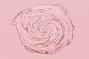 Textured swirling smear of gel with oxygen bubbles on pink background