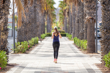 Fototapeta na wymiar Jogging woman on the street of tropical town