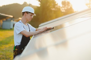 Young adult doing professional training on solar panels plant