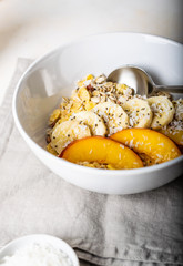 Granola with fruits for breakfast in a deep white plate close-up