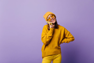 Superior wonderful active girl in yellow total look speaking by her phone with cheerful mood. Portrait of 24 year model on isolated background