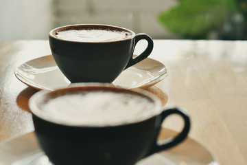 Front view blurred, Hot coffee in a black cup on wooden table.
