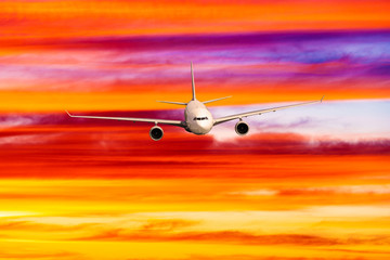 Fototapeta na wymiar Passengers commercial airplane flying above clouds in sunset light.
