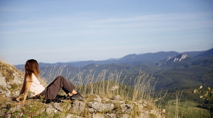 Fototapeta premium Jeune femme en altitude observe le paysage d'Ariège - Montagne nature forêt campagne Pyrénées - voyage tourisme exploration découverte