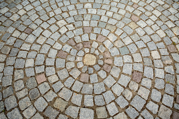 Paver bricks arranged in a circular pattern, architectural background.