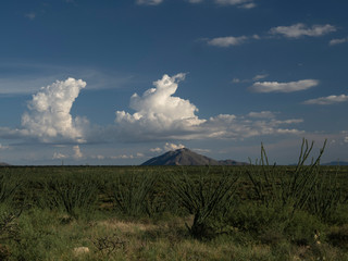 Thunder storms building over a small desert mountain range