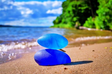 Two blue stones balanced on tropical beach