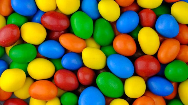 Candy sweets background. Assorted colorful chocolate candies. Colorful delicious sweets turning top view.