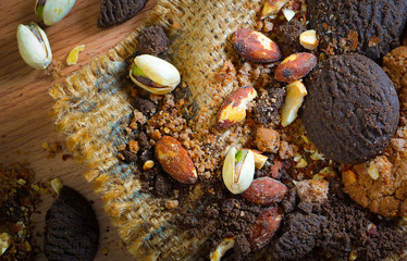 Chocolate, almond nuts on a sack on a wooden table.