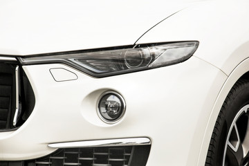 Fototapeta premium Car headlights. Luxury Headlights. Part of a white car close up. Bumper
