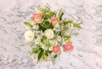 bouquet of roses and greenery on a marble background