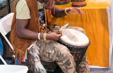 Detail of african drummer beating the drum