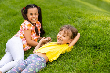 Portrait of two little girls sisters fighting on home backyard. Friends girls having fun. Lifestyle candid family moment of siblings quarreling playing together.