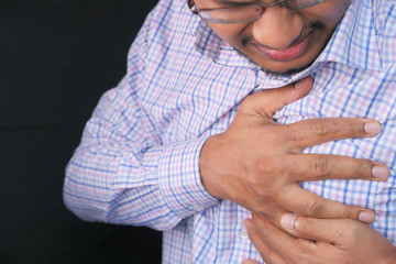 young man suffering heart pain close up 