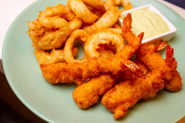 King prawns coated in plain and spicy breadcrumbs and deep-fried. Served with garlic sauce. Close-up, selective focus