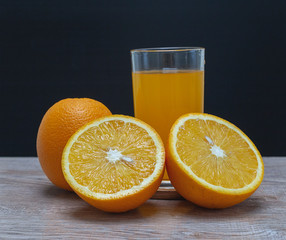 Orange juice in a glass and an orange fruit on the ground