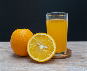 Orange juice in a glass and an orange fruit on the ground
