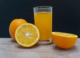 Orange juice in a glass and an orange fruit on the ground