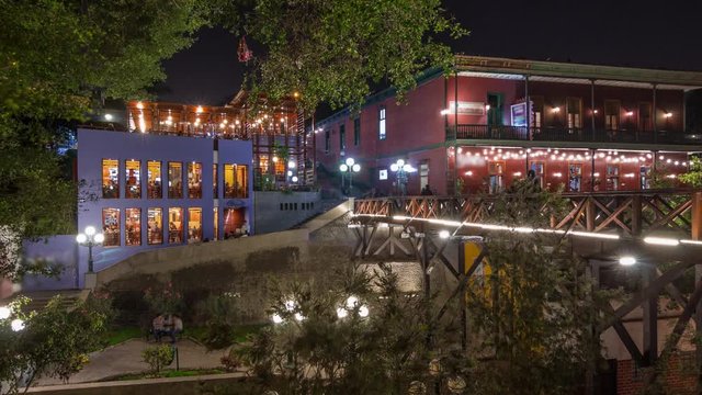 Illuminated Bridge of Sighs night timelapse hyperlapse. Tourists and locals crossing the Bridge of Sighs in the Barranco district of Lima Peru.
