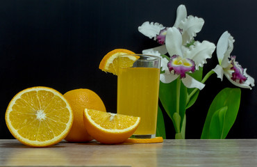 Orange juice in a glass and an orange fruit on the ground