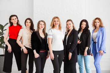 group of women dressed in business style posing and looking at the camera
