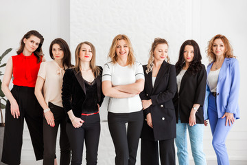 group of women dressed in business style posing and looking at the camera