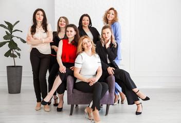 Fototapeta na wymiar Happy women work team employees group looking at camera posing in studio, smiling women company staff workers, workforce members, business people managers standing together, portrait.