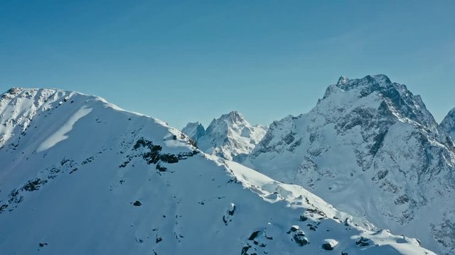 Snow capped mountains on a blue sky in sunny weather, flight, Caucasus mountains