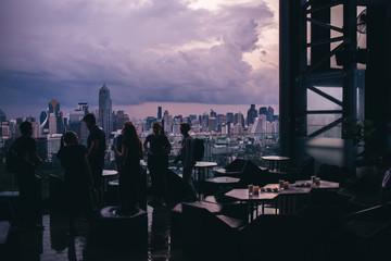 Silhouettes of people talking on terrace of skyscraper