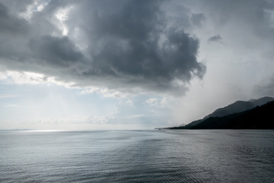 Rain clouds floating in the sky in the middle of the sea © Nippich