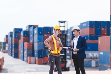 smart creative foreman and engineer woman control loading containers box from cargo freight ship...