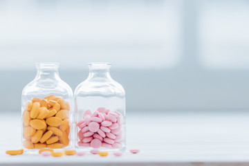 Assorted pharmaceutical medicine pills in glass bottle on wooden table background. Pharmaceutical medicament. Dietary supplements, drugs, Pharmacy, Medicine and healthcare concept.