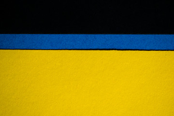 Yellow and black colored paper background divided horizontally with blue stripe