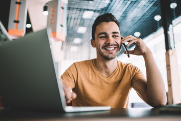 Bright man talking on phone in cafe