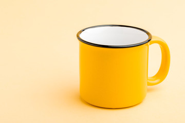 An empty iron mug on a yellow background