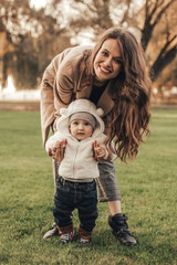 Fototapeta premium Mom and son walking and having fun together in the park.