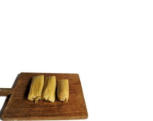 Authentic Tamale with corn leaf on wooden board with white background, typical food of Guatemala