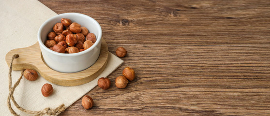 hazelnuts on a plate, on a wooden background with place for text on the right