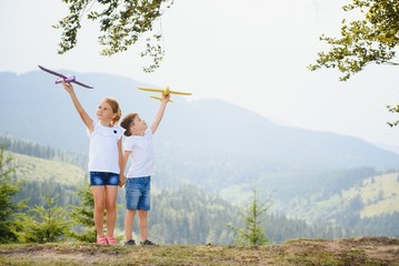 Children pilot aviator with airplane dreams of traveling in summer in nature. Vacation concept.