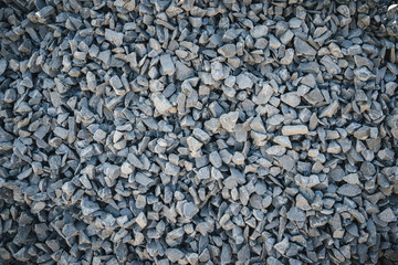 Background close-up photos of the texture details of the crush rock texture background, Grunge and dirty style with a vignette in the corner of the image and bright spot in the middle .