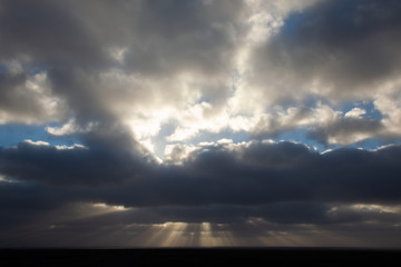 Fototapeta na wymiar sun rays coming out of cloud over the sea