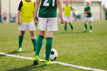 Fototapeta premium School soccer football game. Kids running after soccer ball on grass field. Sports competition between children sport players