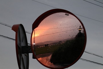 雨模様の中ミラーに映る常夜灯と夕焼け