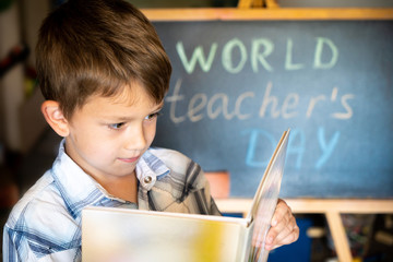 World Teacher's Day greeting, pupil boy near the chalkboard, chalk inscription text