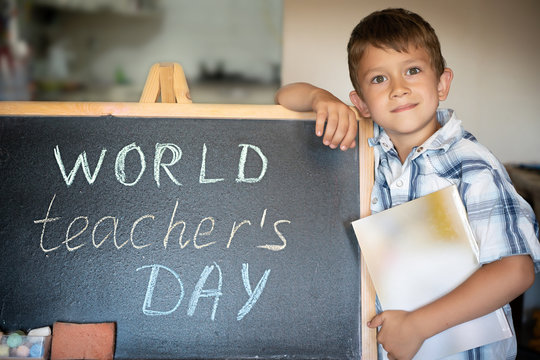 World Teacher's Day greeting, pupil boy near the chalkboard, chalk inscription text - Powered by Adobe