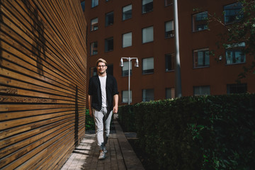 Stylish man walking on street at daytime