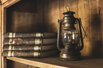 An antique book and an antique lantern are on the shelf. Interior with vintage style.
